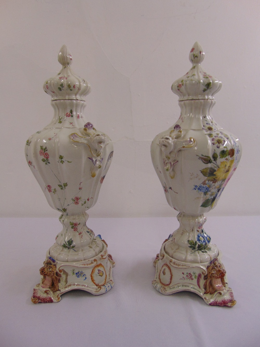 A pair of Italian Majolica ceramic vases on detachable stands and with pull off covers decorated