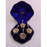 A cased set of four Edwardian silver salts with matching spoons and detachable glass liners,