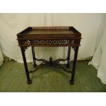 An Oriental rectangular hardwood drinks table, scroll pierced gallery and sides on four stylised