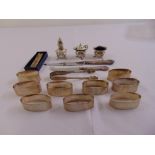 A quantity of silver to include napkin rings, a three piece condiment set, a cheese knife with