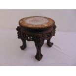 A Chinese hardwood plant stand of circular form profusely carved with marble inset to the top
