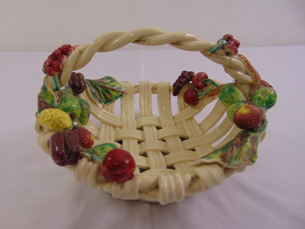 A Majolica style lattice work ceramic fruit basket decorated with applied fruit and leaves