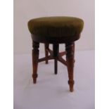 An oak circular rise and fall piano stool on four turned legs