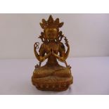 A Tibetan gilded metal Buddha on raised lotus throne