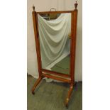 A rectangular Cheval mirror, the supports surmounted with urn finials, on scroll legs with brass