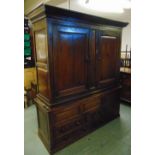 An 18th century rectangular oak cupboard with hinged panelled doors, the plinth base with drawers
