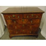 An early 18th century Queen Anne walnut chest of drawers, with brass drop handles and escutcheons on