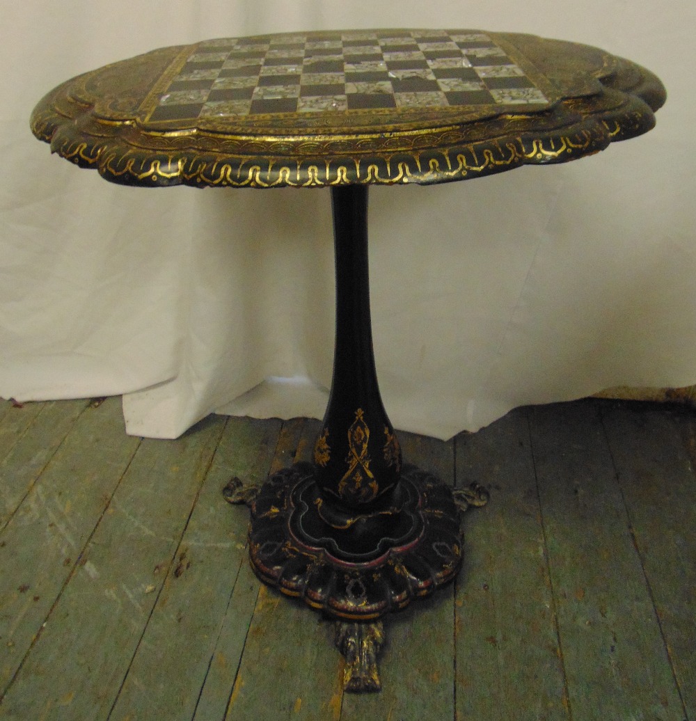 A Victorian ebonised papier mache oval tilt-top games table by Jenners & Bettridge inlaid with