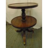 A 19th century circular mahogany two tier dumb waiter trolley on tripod feet with brass caps and