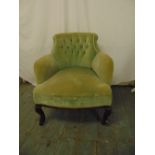 An early 20th century mahogany upholstered tub chair on scroll legs