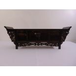 An Oriental rectangular ceremonial hardwood alter carved with dragons and comical figures