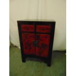 An Oriental rectangular lacquered cabinet with two drawers and hinged doors