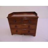 A rectangular mahogany table-top apprentice chest of drawers with turned wooden handles