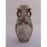 A Chinese pear shaped vase decorated with raised flowers and two panels with various figures, A/F