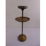 An early 20th century brass ashtray stand on raised circular base
