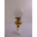 A Victorian style glass and brass oil lamp with globular shade and square base