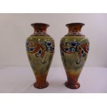 A pair of Doulton baluster vases decorated with scrolls on raised circular bases, marks to the