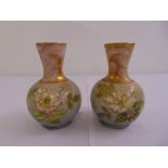 A pair of hand painted baluster vases, decorated with flowers and leaves, marks to the bases