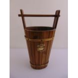 A wooden umbrella stand in the form of a milk bucket