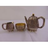 An Oriental style three piece white metal teaset decorated with bamboo stamped by Grish Chunder Dutt