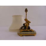 An early 20th century gilt metal and marble table lamp with a cast figurine of a putti fighting a
