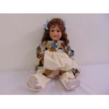 An early 20th century bisque head doll with blue eyes, marks to reverse of head A.390.M.8