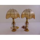 A pair of gilt metal table lamps with glass lustres and glass shades