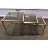 A nest of three gilt metal and glass rectangular side tables