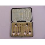 A cased set of silver Apostle spoons and matching tongs