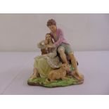 A continental porcelain figurine of a courting couple with two dogs