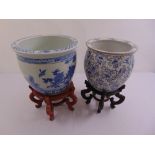 Two Chinese blue and white fish bowls on carved hardwood stands