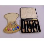 A cased set of silver and enamel teaspoons and a cased set of silver grapefruit spoons