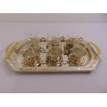 Six white metal tea glass holders with glass cups and a silver plated tray
