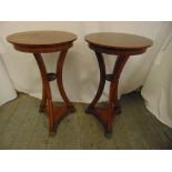 A pair of mahogany inlaid side tables of circular form on three arched supports terminating in brass