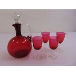 A cranberry glass decanter and four late 19th century glasses