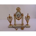 A French gilt metal and white marble mantle clock supported by four columns and flanked by vase form