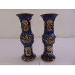 A pair of Chinese blue ground baluster vases decorated with village scenes