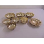 Seven white metal dishes of circular form with beaded borders and a silver plated sugar bowl