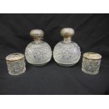 Two cut glass and silver perfume bottles and two cotton wool jars with silver pull-off covers