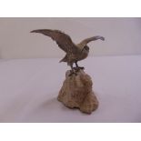 A silver model of a bird on a naturalistic stone base retailed by Garrards, to include original