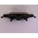 An ebonised hat and coat wall mounted stand decorated with a carved eagle