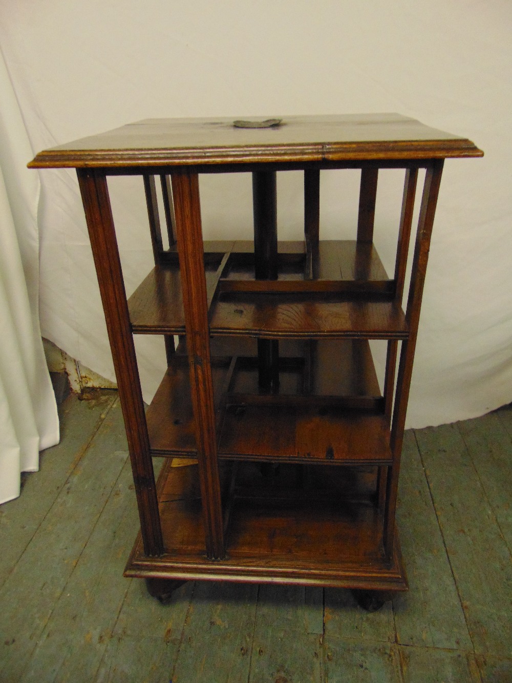 An oak revolving Canterbury bookcase possibly made from wood from the Flagship at the Battle of