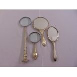 Two silver hand mirrors and two magnifying glasses one with Mother of Pearl handle