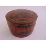 An Oriental circular papier mache rice box with pull-off cover