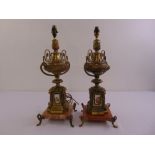 A pair of gilt metal table lamps with applied porcelain panels on rectangular marble bases