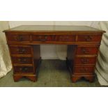 A mahogany rectangular leather top pedestal desk with nine drawers and brass swing handles