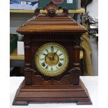 An Antique carved mantel clock with enamel and bra