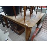 An Edwardian pine kitchen table raised on square o