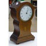 An Edwardian oak cased mantel clock with shell mot