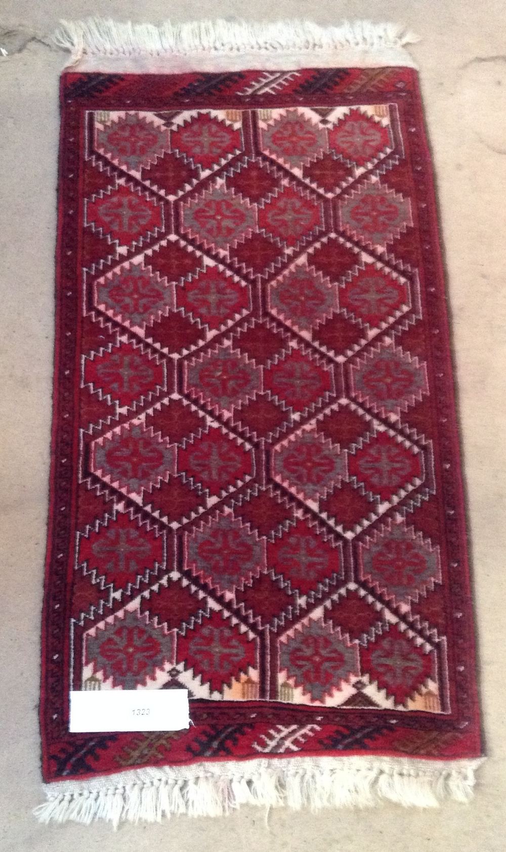 A small red ground Persian rug, 3'3" x 1'9".